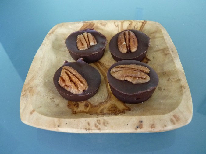  Mini-Muffinform halb gefüllt und mit einer Pecannuss garniert, echt lecker